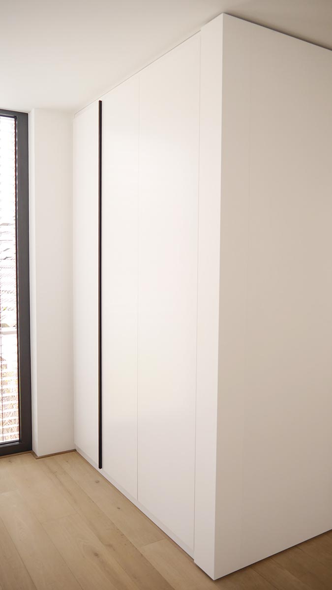 Garderobenschrank mit raumhohen Drehtüren und Design-Griffleisten