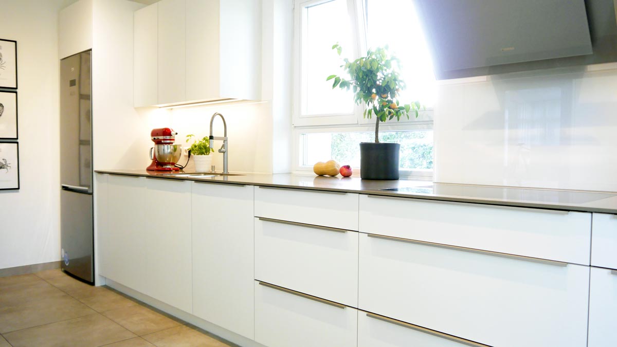 Der freistehende Kühlschrank aus dem Bestand wurde mittels Passblenden ins Küchen-Design integriert.