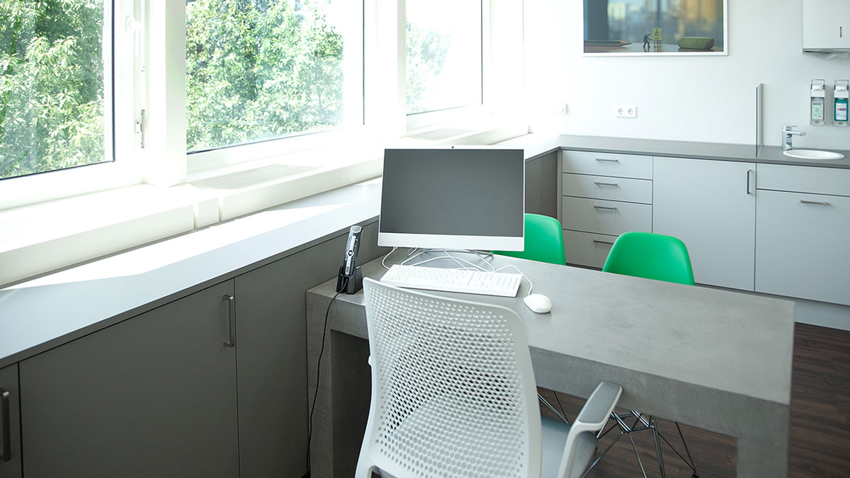 In den Komponenten sind sich die Behandlungsräume recht ähnlich: Schreibtisch in Beton-Optik, Sideboards, mit Waschbecken und Hochschränke für zusätzlichen Stauraum