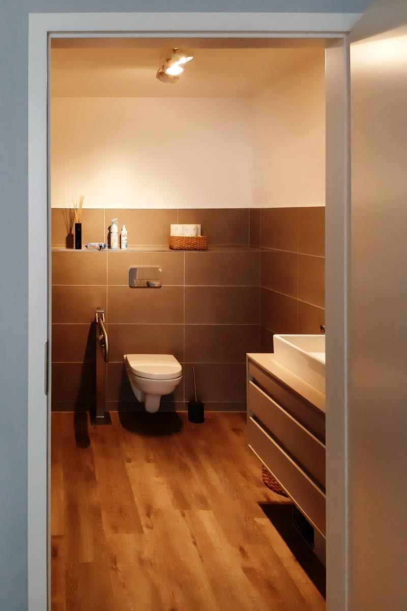 WC behindertengerecht mit Stützgriff und Waschtisch in grau mit Aufsatzwaschbecken
