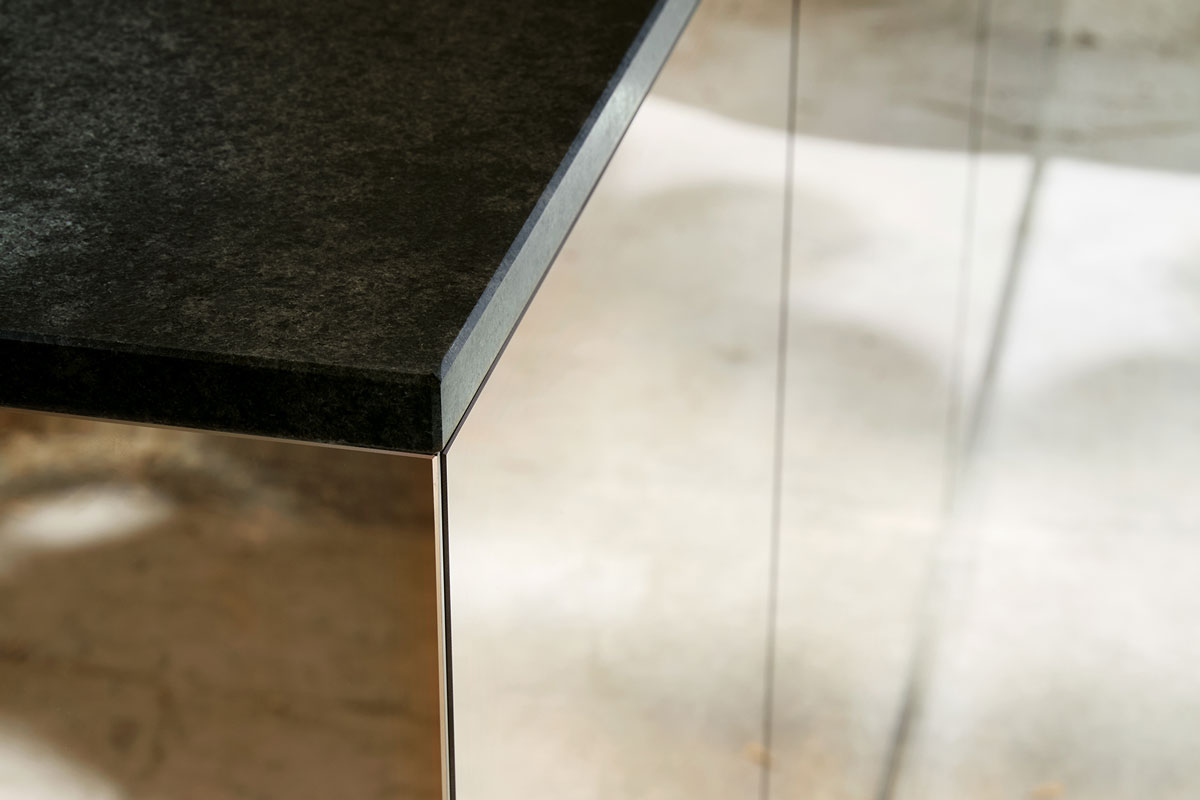 Beinahe schwarzer Naturstein trifft auf Spiegelglas Bronze
