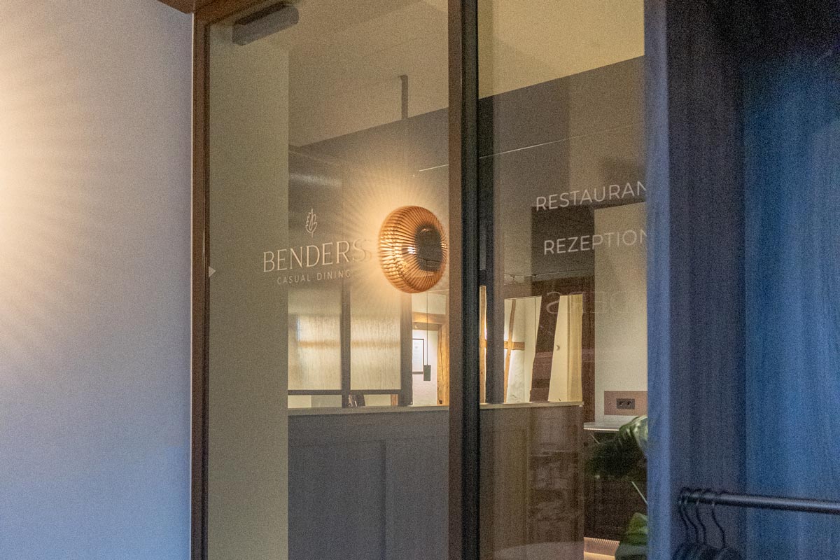 Glasschiebetür mit BENDERS Logo und Garderobe